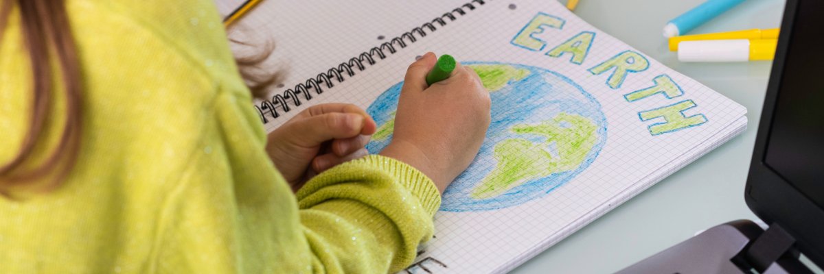 Child girl draws planet earth with wax colors on school notebook for Earth day - Little activist writes the message Save the Planet - Childhood, protection of environment and global warming concept Child girl draws planet earth with wax colors on school notebook for Earth day - Little activist writes the message Save the Planet - Childhood, protection of environment and global warming concept