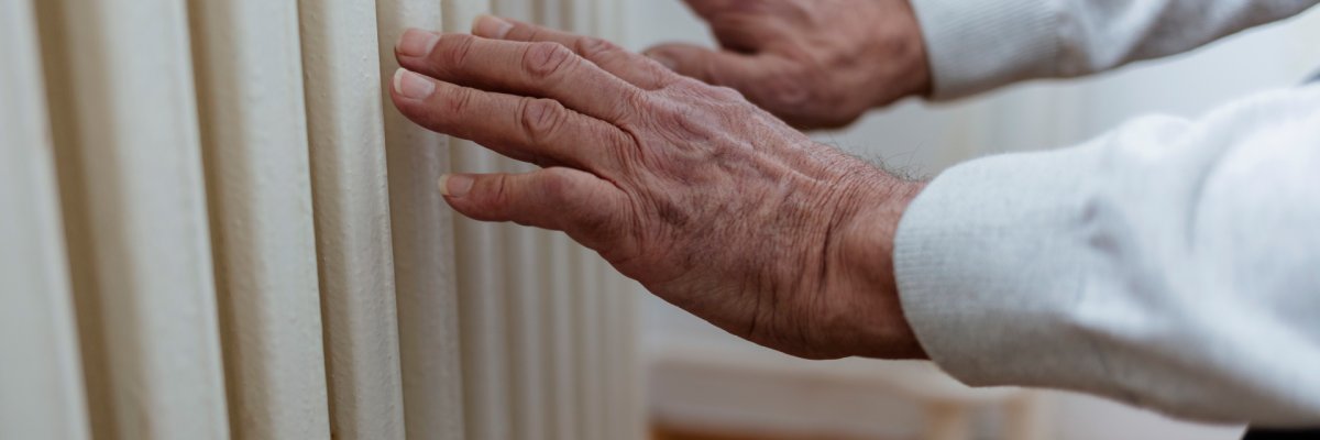 Man warms up hands over heater. Man warms up hands over heater.
